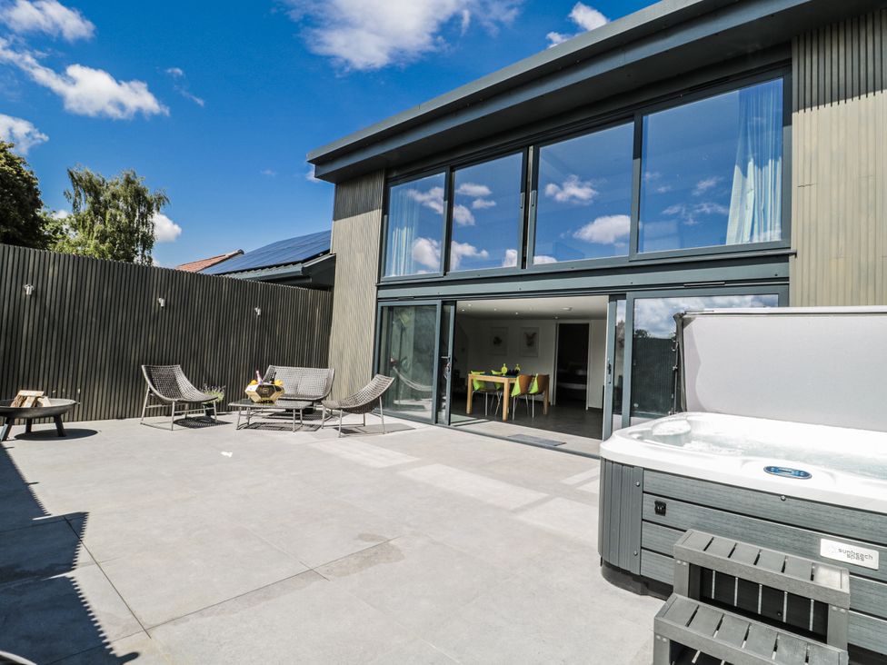 An outdoor patio area with a hot tub and seating at Number 7 in Bishop Sutton