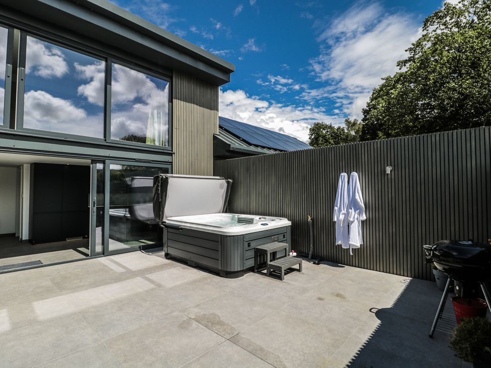 An outdoor area with a hot tub and a sliding glass door at Number 7 in Bishop Sutton