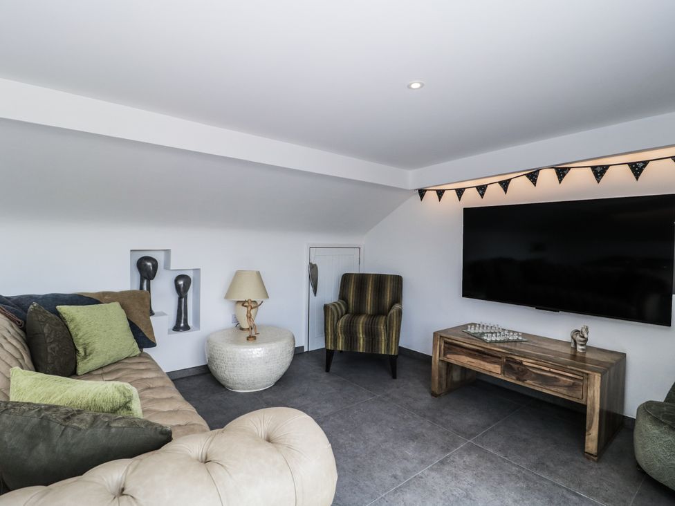 A snug with a sofa, armchair, and television at Number 7, Bishop Sutton