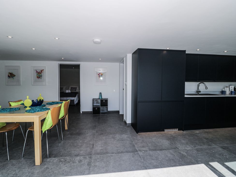 A kitchen with a dining area and black cabinets at Number 7 Bishop Sutton