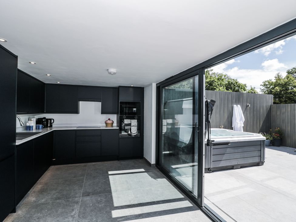 A kitchen with cabinets and a hot tub at Number 7 in Bishop Sutton