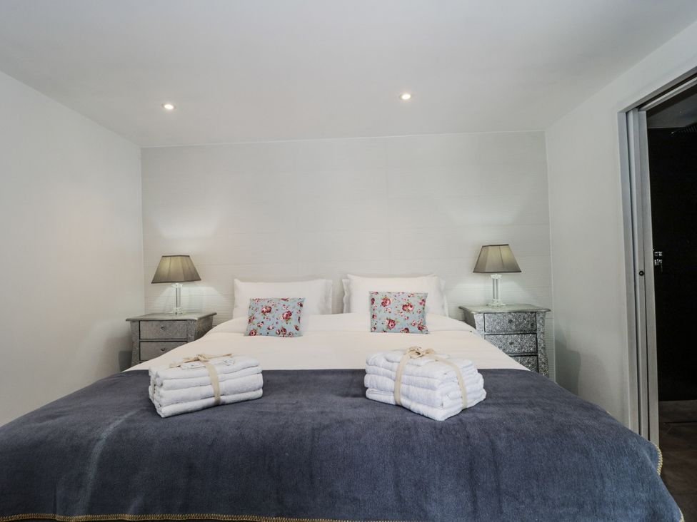 A bedroom with a bed and bedside tables at Number 7 in Bishop Sutton