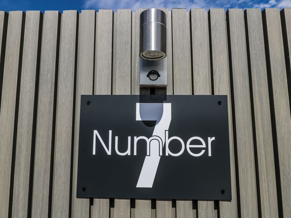 A number sign and a light fixture at Number 7 in Bishop Sutton