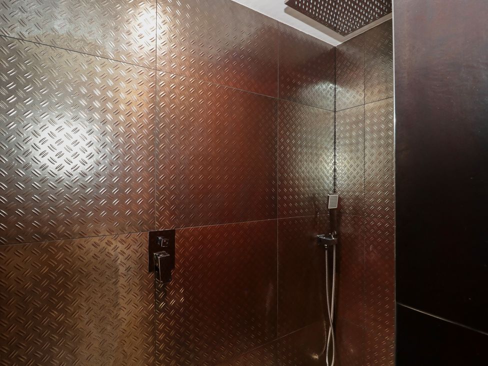 A shower with metal wall panels at Number 7 in Bishop Sutton
