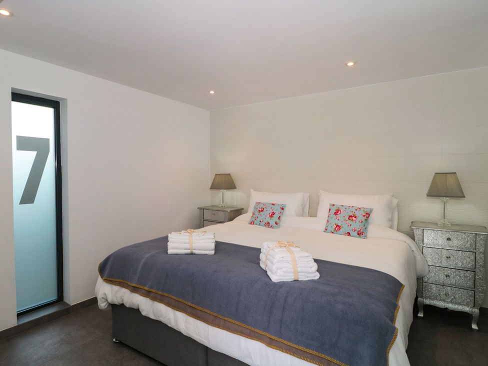 A bedroom featuring a bed with towels and bedside lamps at Number 7, Bishop Sutton