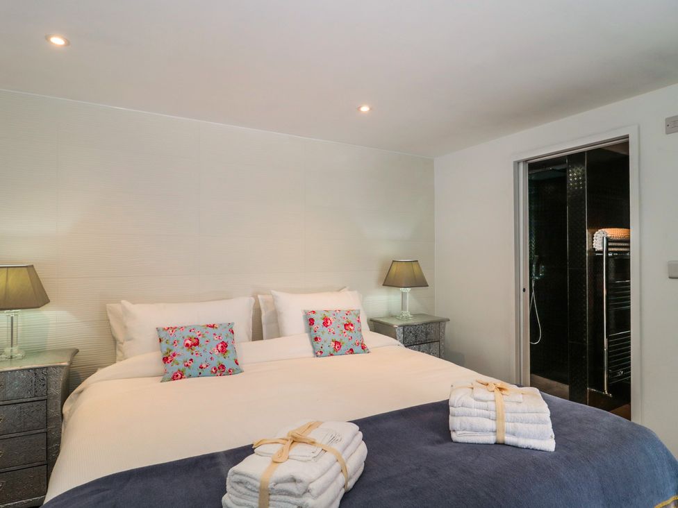 A bedroom with a bed and lamps at Number 7 in Bishop Sutton