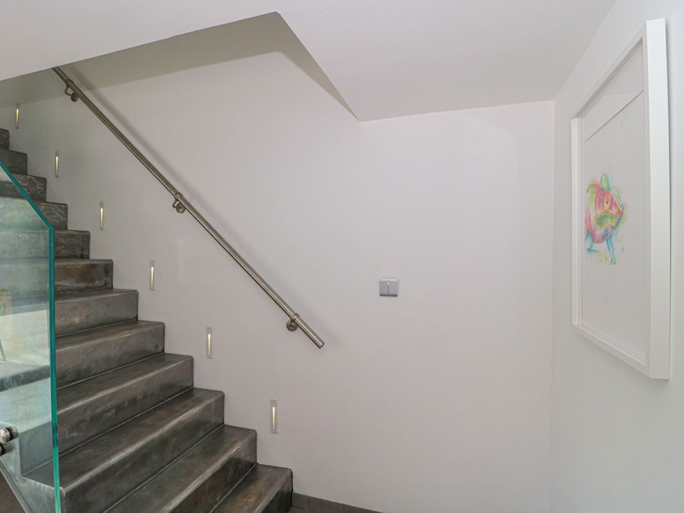 A staircase with a handrail and wall art at Number 7 in Bishop Sutton