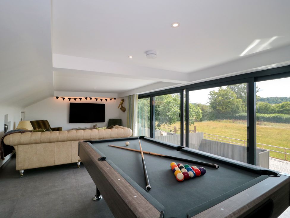 A game room with a pool table and sofa at Number 7 in Bishop Sutton