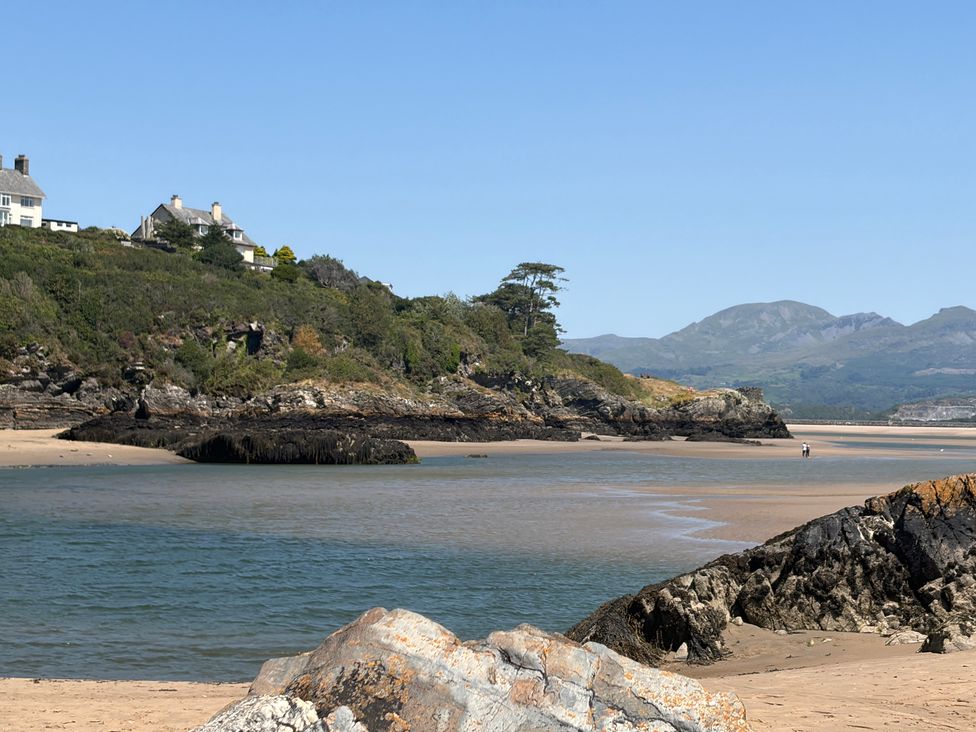 A beach scene with rocks and houses at The Quarterdeck in Borth-Y-Gest