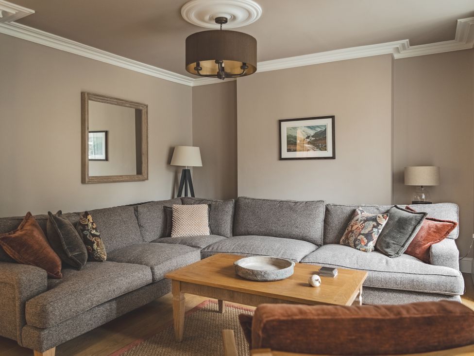 A living room with a grey sofa and coffee table at Tan Llan in Llanelltyd near Dolgellau
