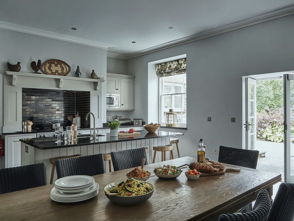 A kitchen with dining table and various food preparations at Tan Llan in Llanelltyd near Dolgellau