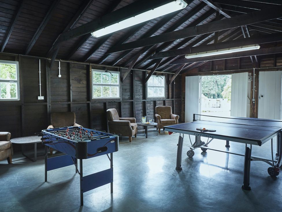 A game room with a foosball table and ping pong table at Tan Llan in Llanelltyd near Dolgellau