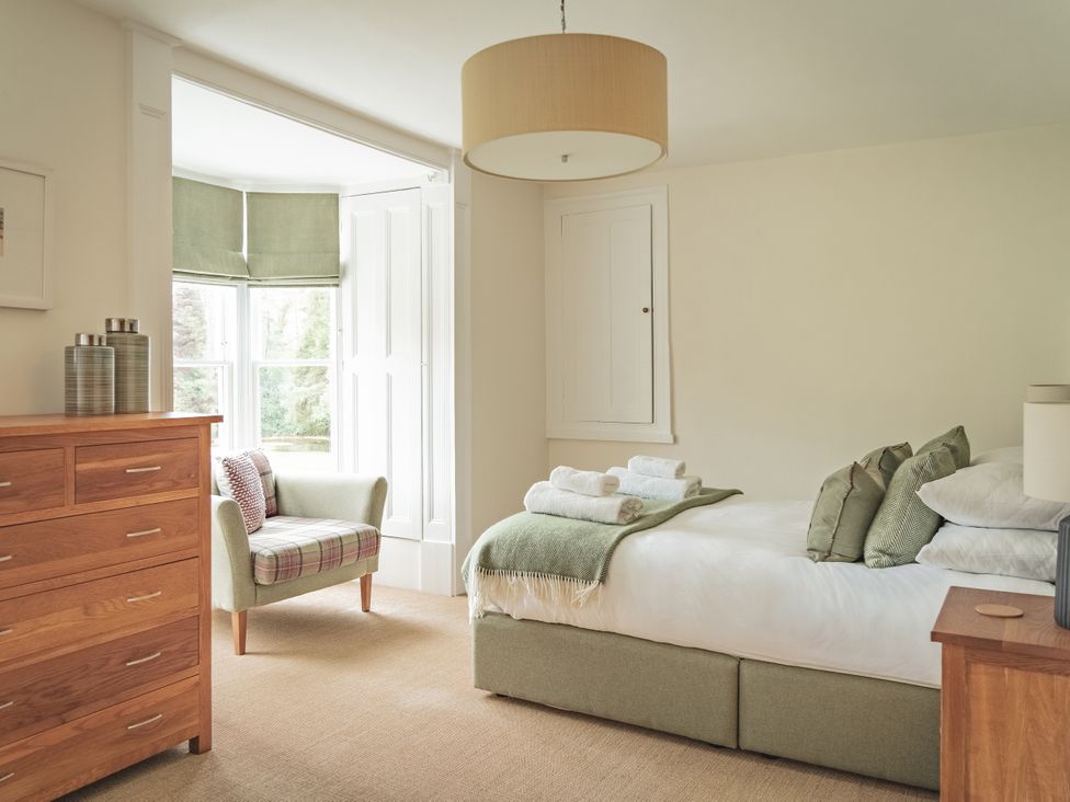 A bedroom with a bed and a sofa at Tan Llan in Llanelltyd near Dolgellau