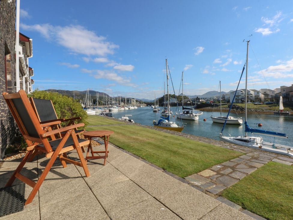 A view of sailing boats on water with deck chairs at 1 Oakley Wharf Porthmadog