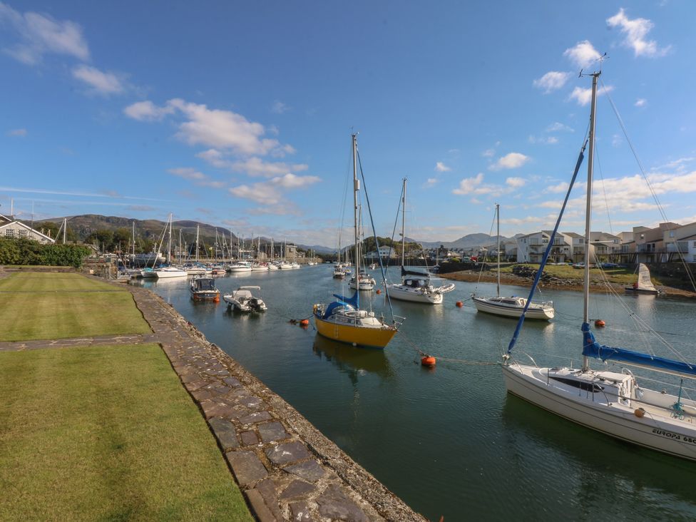 A marina with boats along a channel at 1 Oakley Wharf Porthmadog