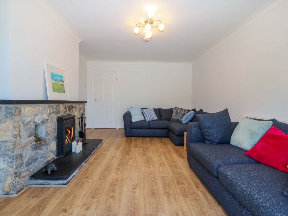 A living room with a fireplace and sofas at 20 Gwelfor Estate Cemaes Bay