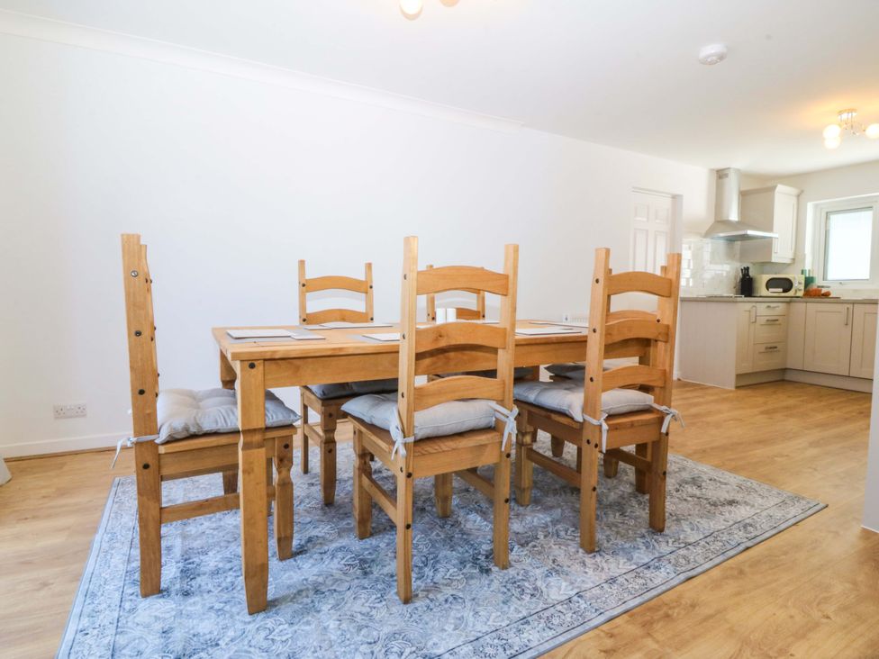 A dining room with a table and chairs at 20 Gwelfor Estate, Cemaes Bay