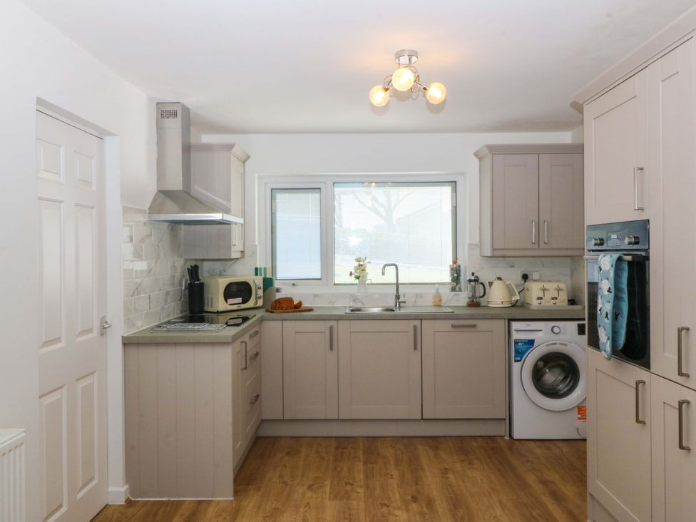 A kitchen with a sink and microwave at 20 Gwelfor Estate in Cemaes Bay