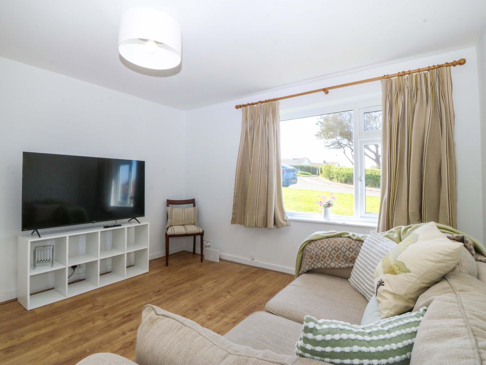 A living room with a television and sofa at 20 Gwelfor Estate in Cemaes Bay