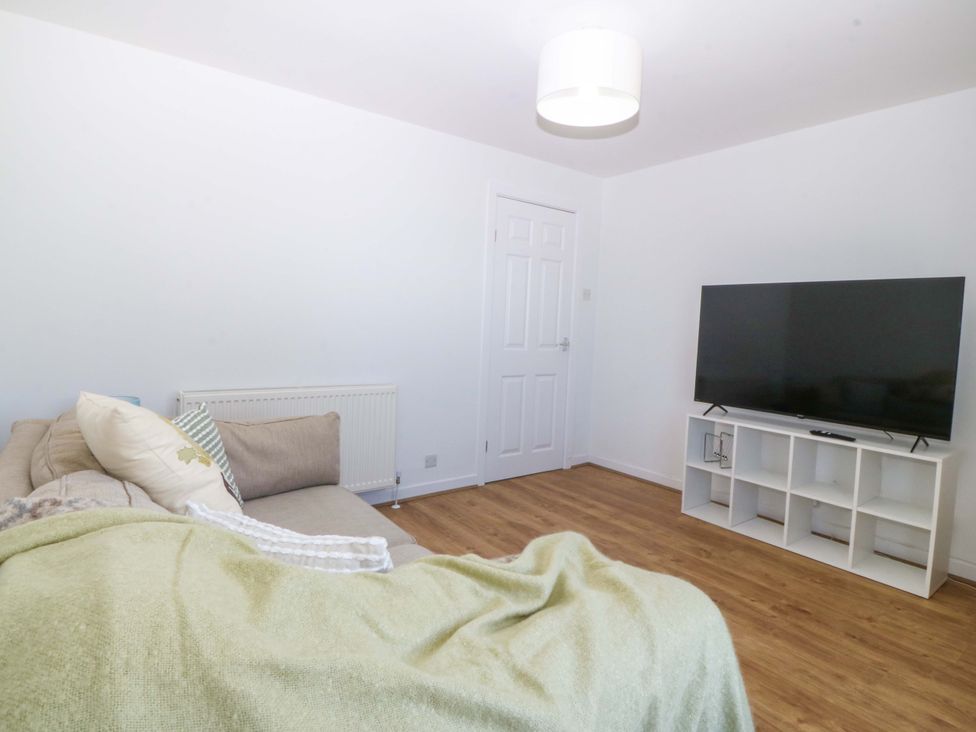 A living room with a sofa and television at 20 Gwelfor Estate Cemaes Bay