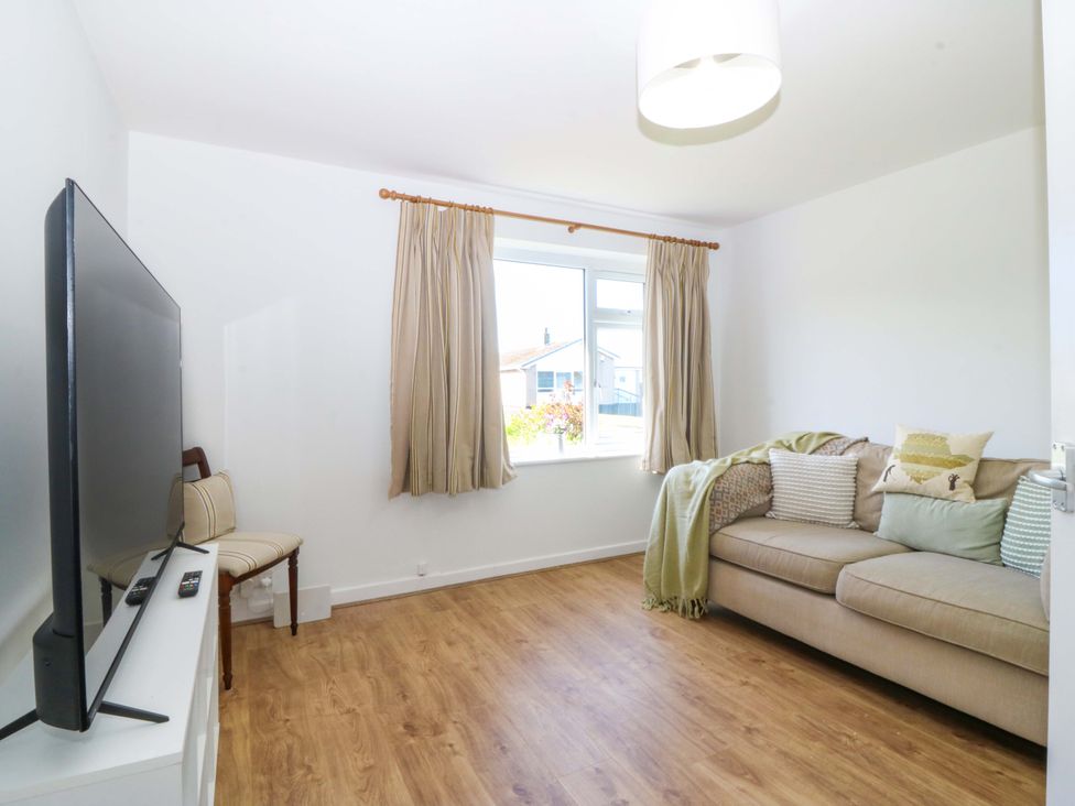 A living room featuring a television and a sofa at 20 Gwelfor Estate Cemaes Bay