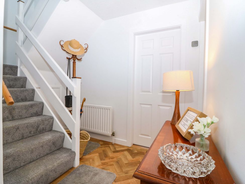 A hallway with stairs and a lamp at 20 Gwelfor Estate, Cemaes Bay