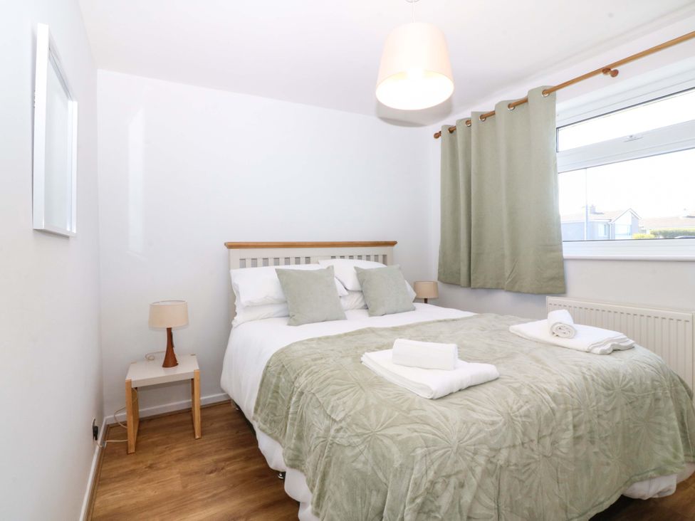 A bedroom with a bed and a window at 20 Gwelfor Estate Cemaes Bay