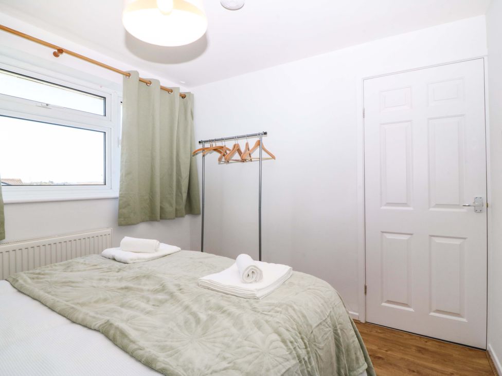 A bedroom with a bed and clothes rack at 20 Gwelfor Estate in Cemaes Bay
