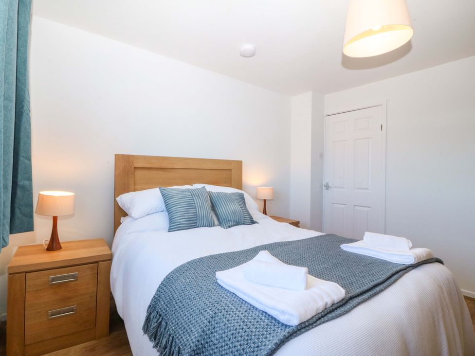A bedroom with a bed and bedside table at 20 Gwelfor Estate in Cemaes Bay