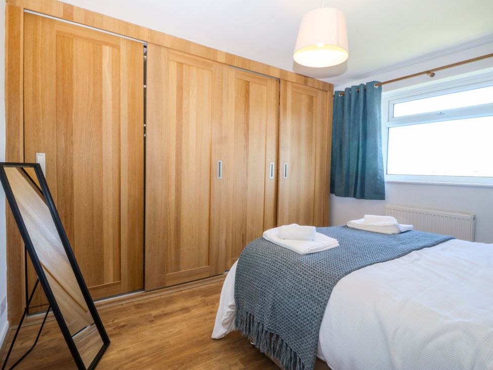 A bedroom with a bed and wardrobe at 20 Gwelfor Estate in Cemaes Bay
