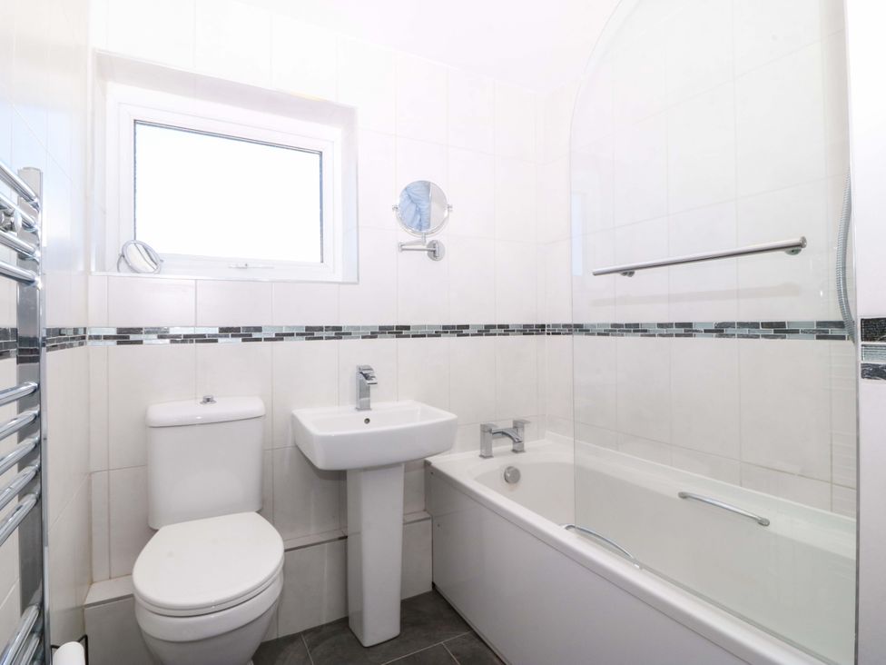 A bathroom with a toilet, sink, and bathtub at 20 Gwelfor Estate in Cemaes Bay