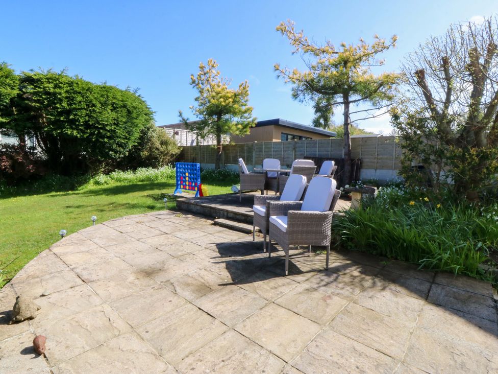 A garden with chairs and table on a patio at 20 Gwelfor Estate Cemaes Bay