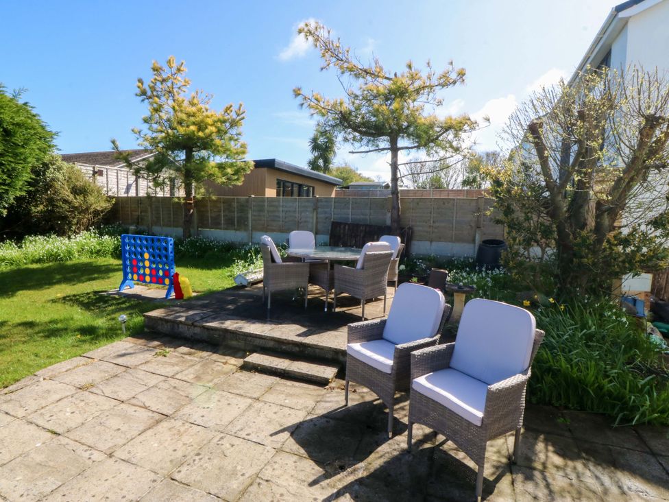 A garden with a table and chairs and a connect four game at 20 Gwelfor Estate in Cemaes Bay