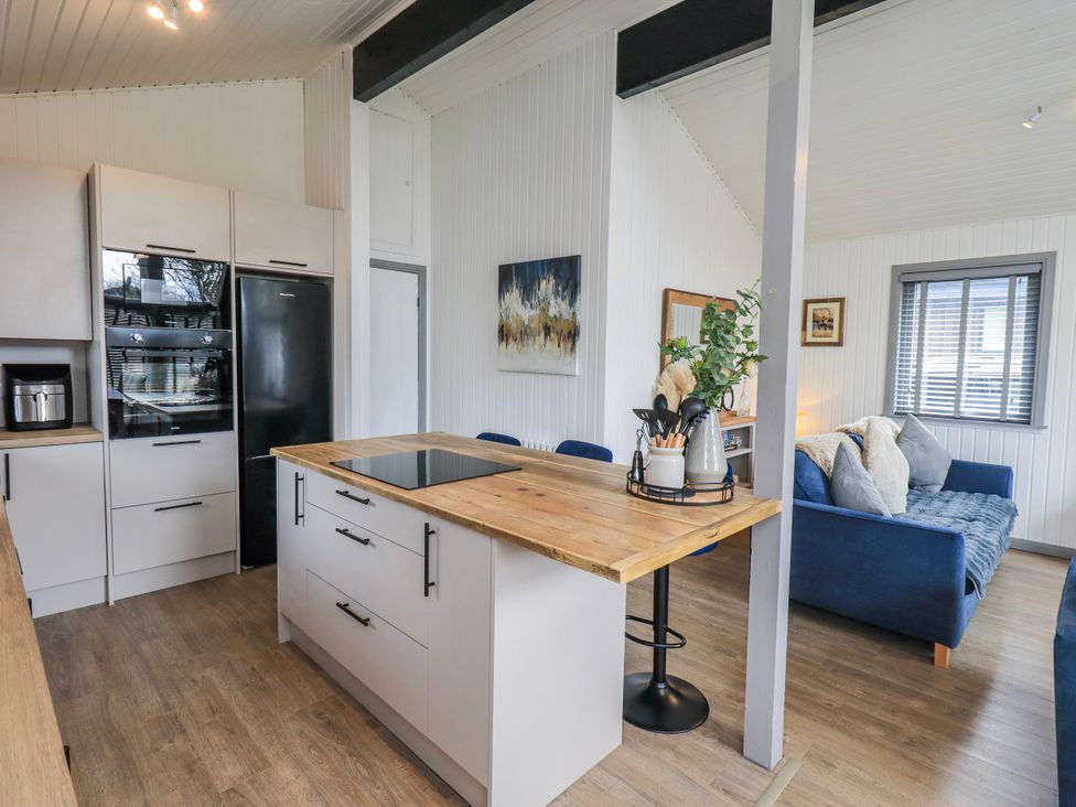 A kitchen with an island and sofa at Fig Tree Lodge in Hutton Roof near Penrith