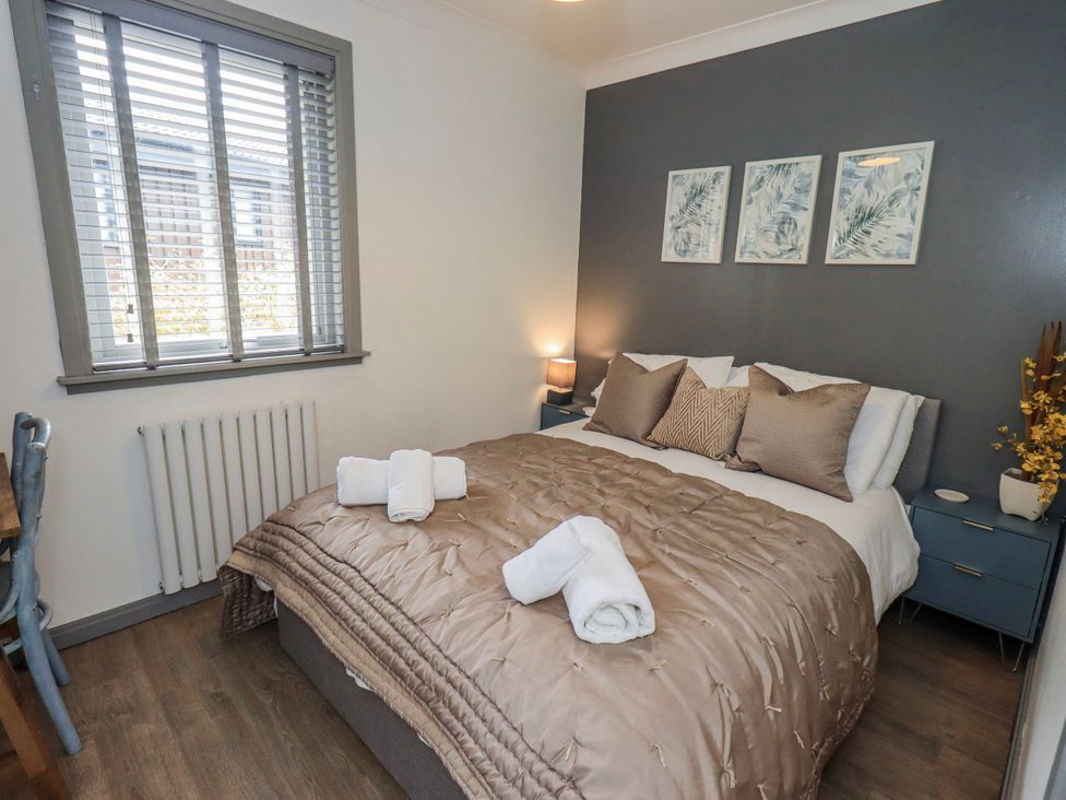 A bedroom with a bed and bedside table at Fig Tree Lodge Hutton Roof near Penrith