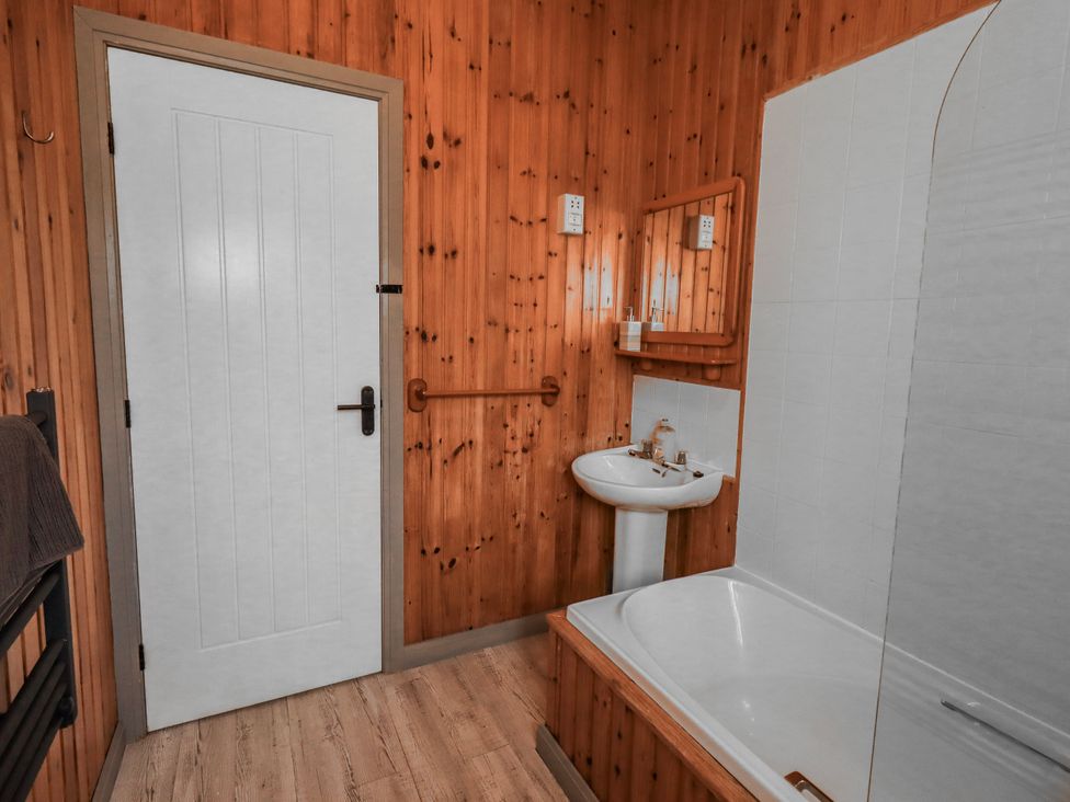 A bathroom with a bathtub and sink at Fig Tree Lodge in Hutton Roof near Penrith