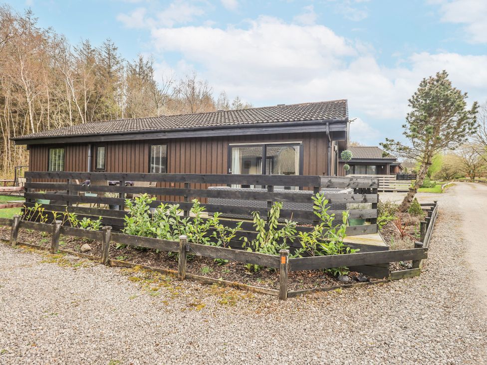 A house with a fence and plants in front at Fig Tree Lodge in Hutton Roof near Penrith