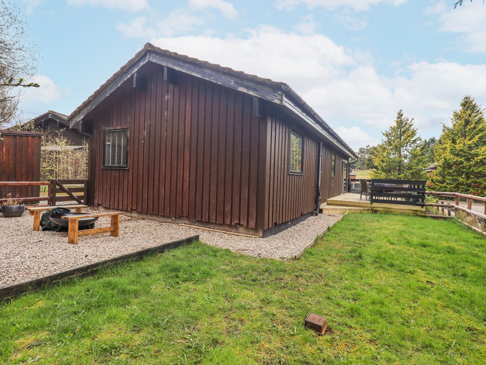 An outdoor view of a wooden cabin with decking at Fig Tree Lodge Hutton Roof near Penrith