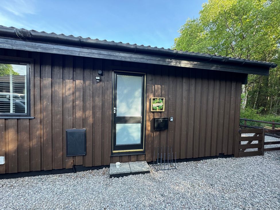An exterior view of a wooden cabin with a door and windows at Fig Tree Lodge in Hutton Roof near Penrith