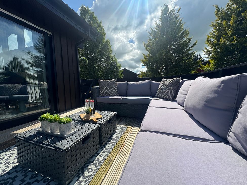 An outdoor seating area with a sofa and coffee table at Fig Tree Lodge Hutton Roof near Penrith