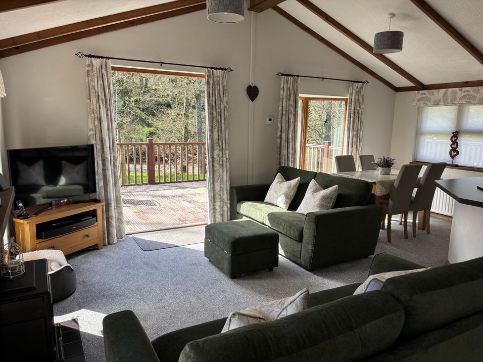 A living room with a sofa and television at 2 Riverside Lodge near Cenarth