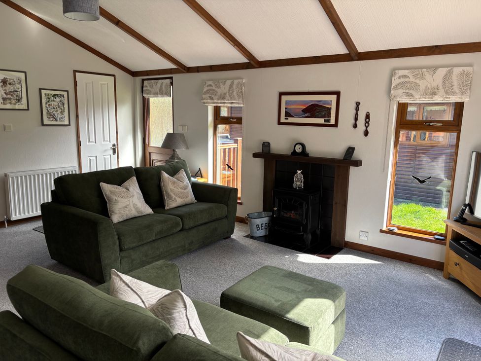 A living room with a sofa and television at 2 Riverside Lodge Abercych near Cenarth