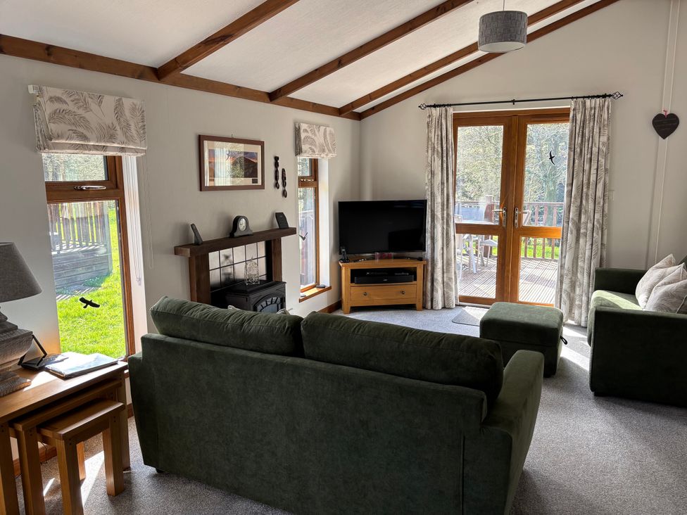 A living room with a sofa and television at 2 Riverside Lodge Abercych near Cenarth