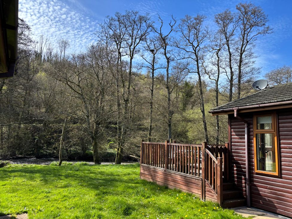 An outdoor area with trees and grass at 2 Riverside Lodge Abercych near Cenarth