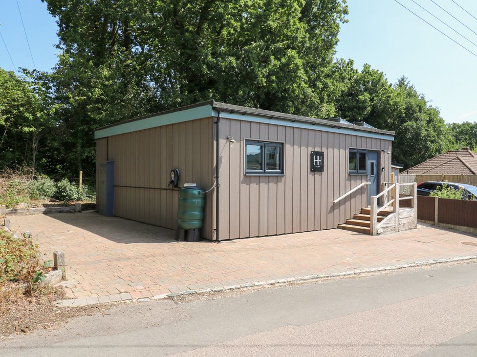 An outdoor view of a building with steps and a rainwater tank at Hub House in Three Oaks near Hastings
