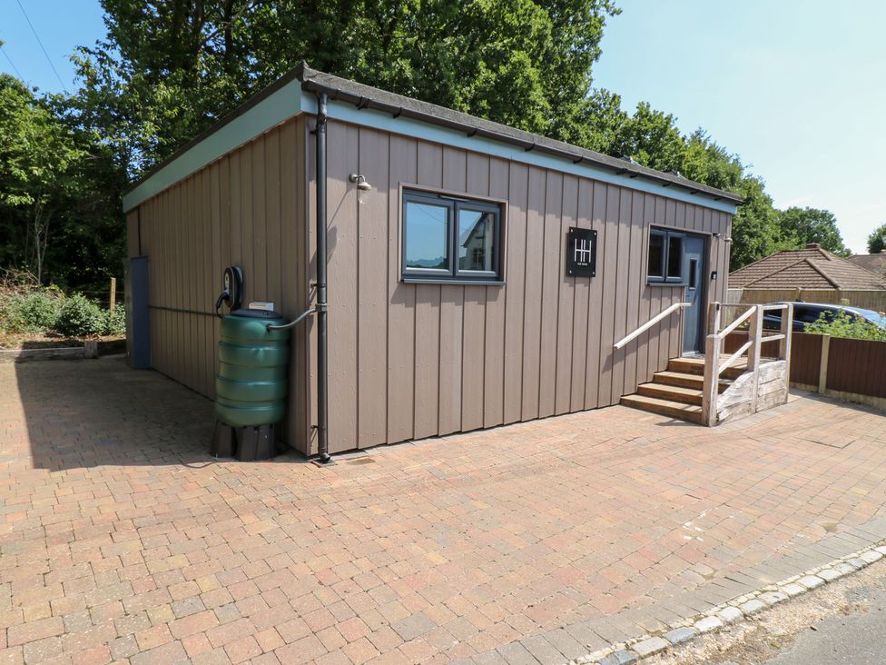 An exterior view of a building with steps and a water tank at Hub House Three Oaks near Hastings