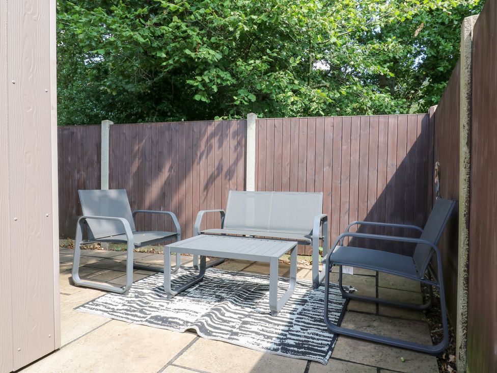 An outdoor patio with seating and a table at Hub House Three Oaks near Hastings
