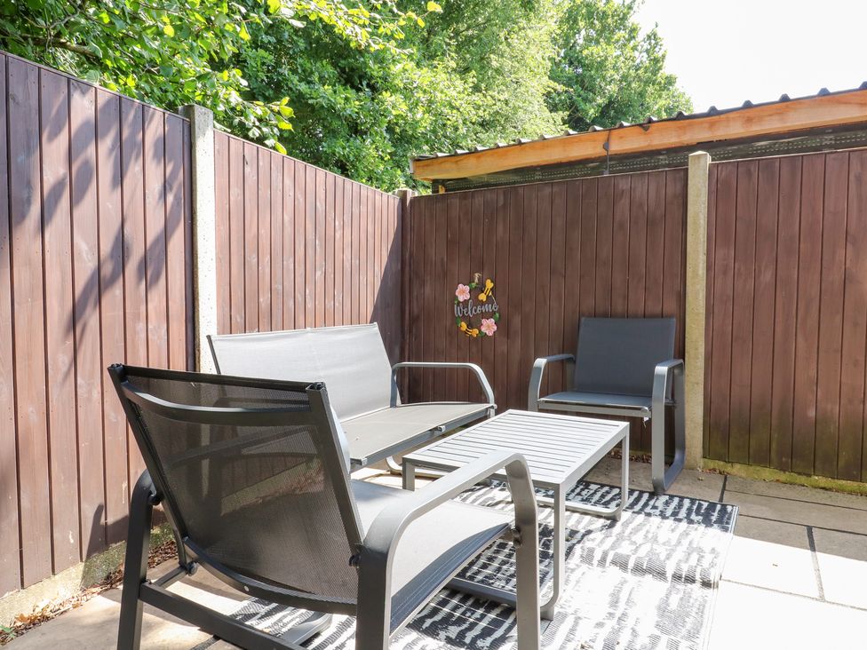 An outdoor patio with seating and a table at Hub House in Three Oaks near Hastings