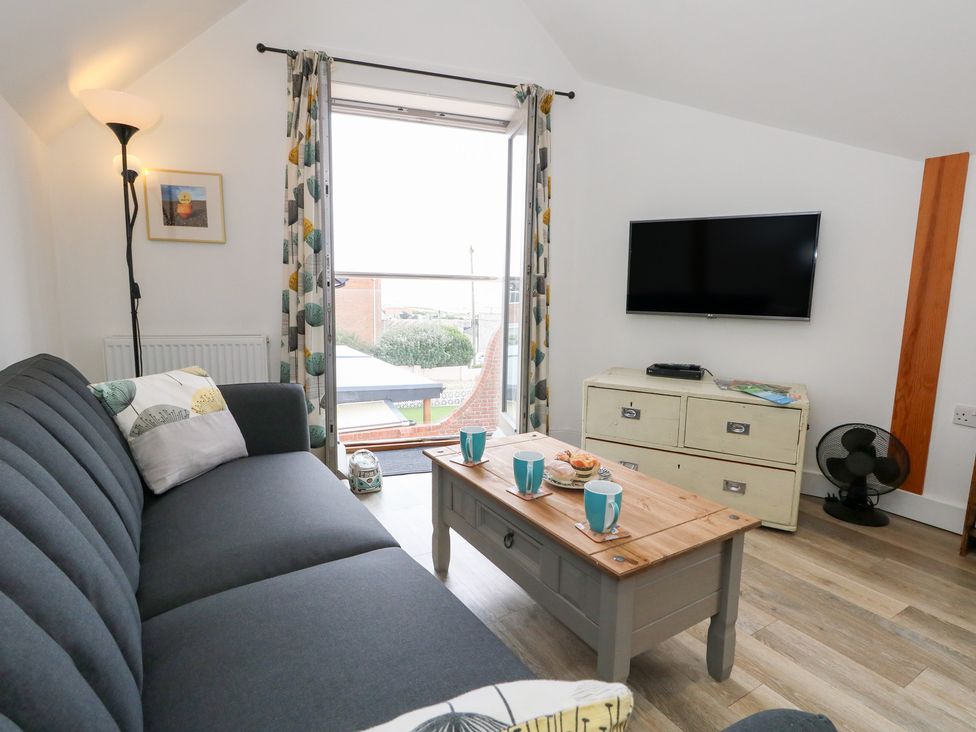 A living room with a sofa and coffee table at Coastguard Lookout in Wyke Regis