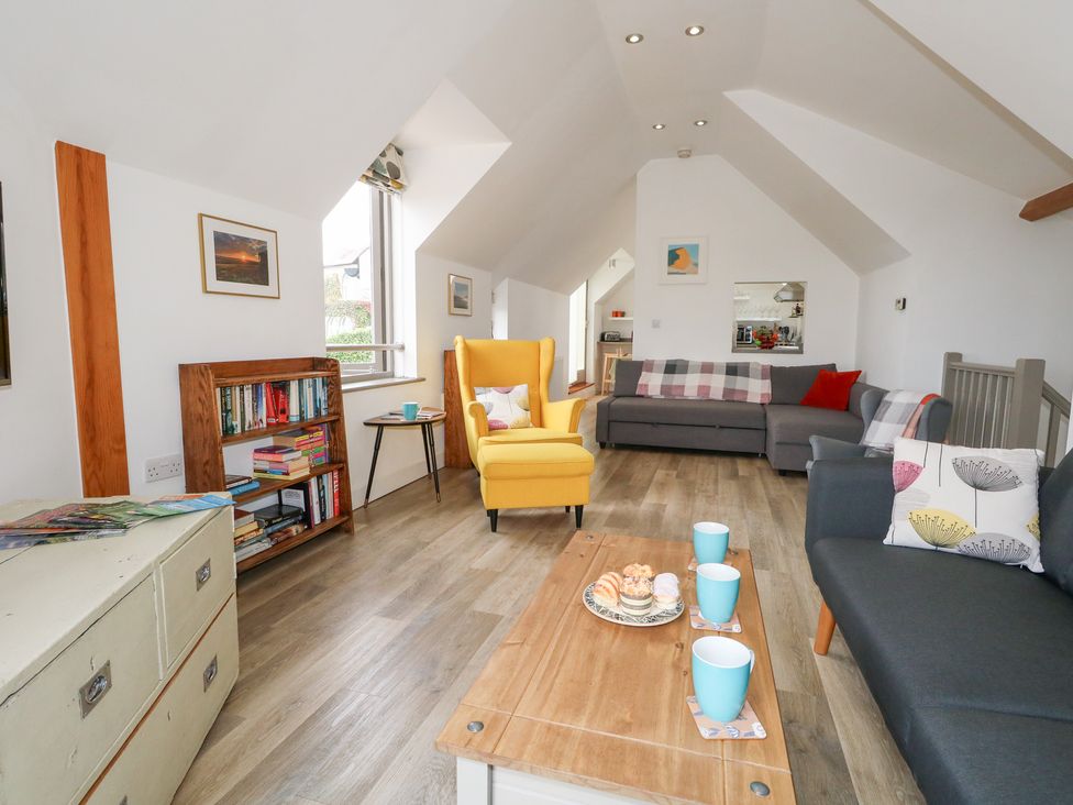 A living room with seating and a bookshelf at Coastguard Lookout in Wyke Regis